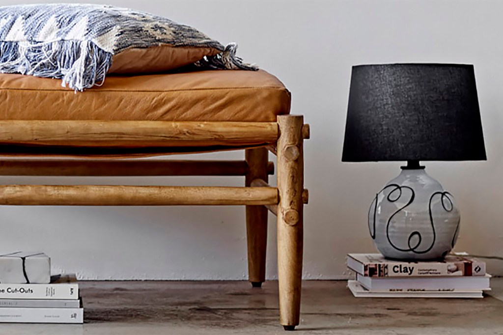 A wooden bench and a black and gray lamp 