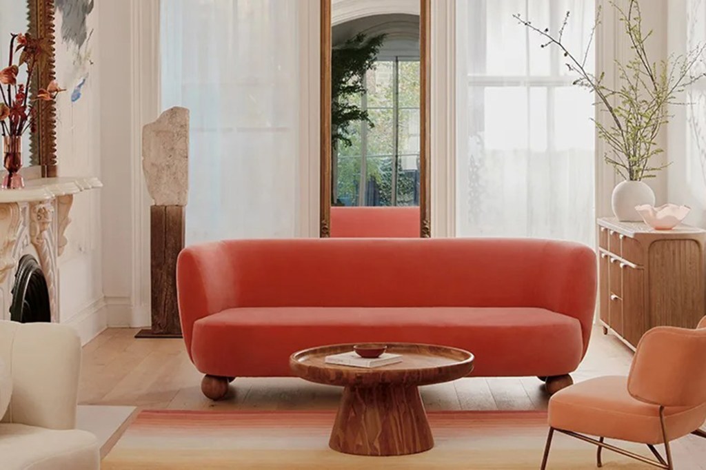 pink couch next to peach chair and wooden coffee table