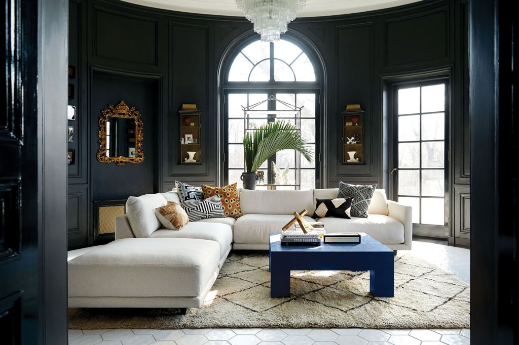 A large living room with dark blue walls and a large white sofa 