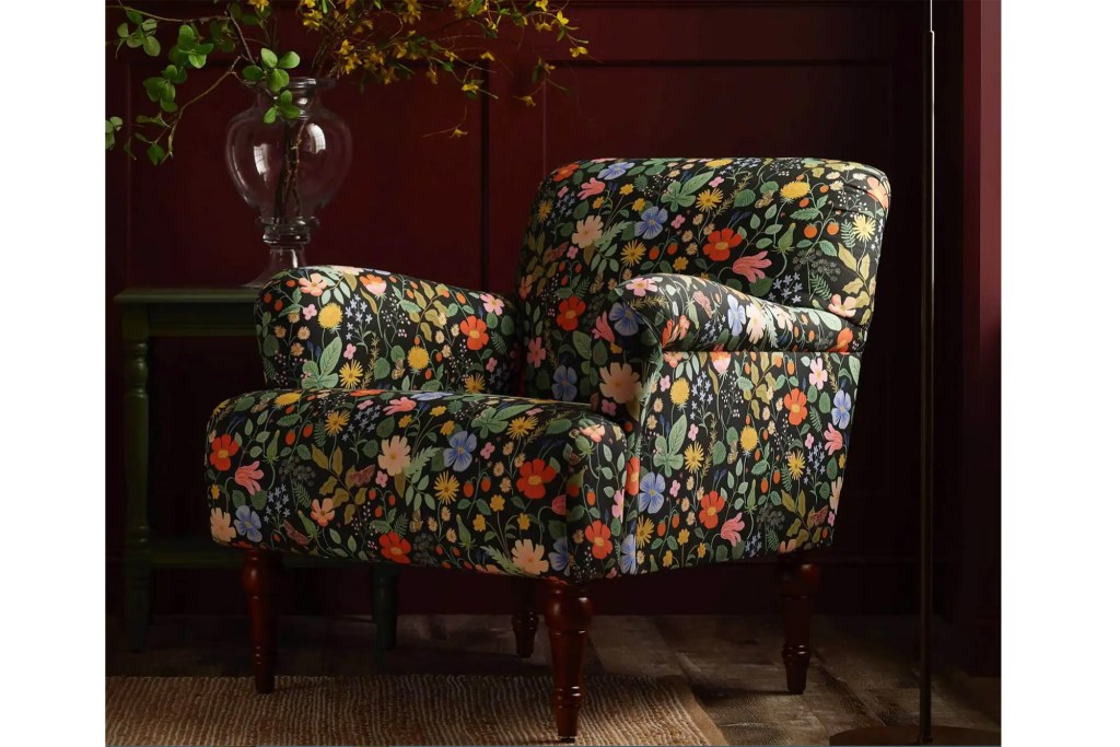 A floral armchair in a dark red room. 