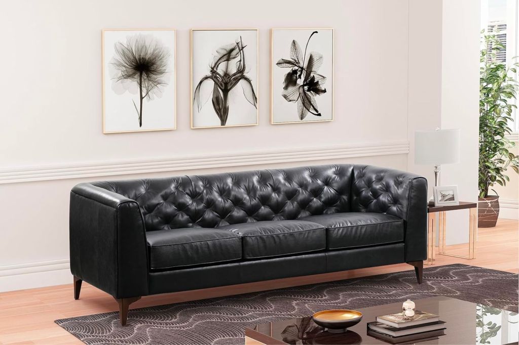 A black leather sofa inside a living room setting.