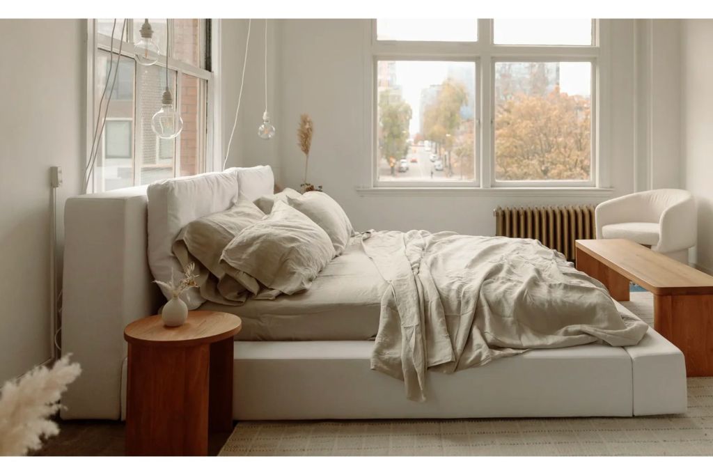 A bed in front of a large window.