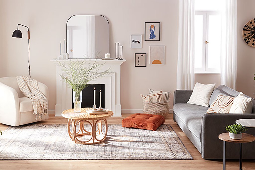 A white living room with gray couch and white chair and a brown round table in the center 