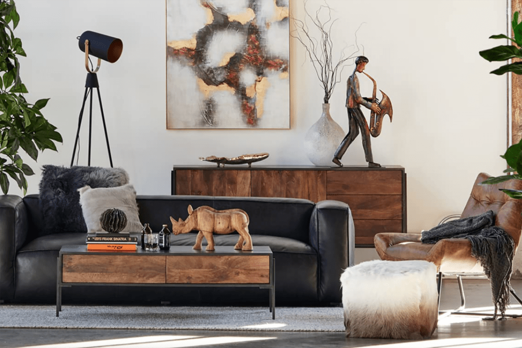 A living room with a black couch and white and wood details 